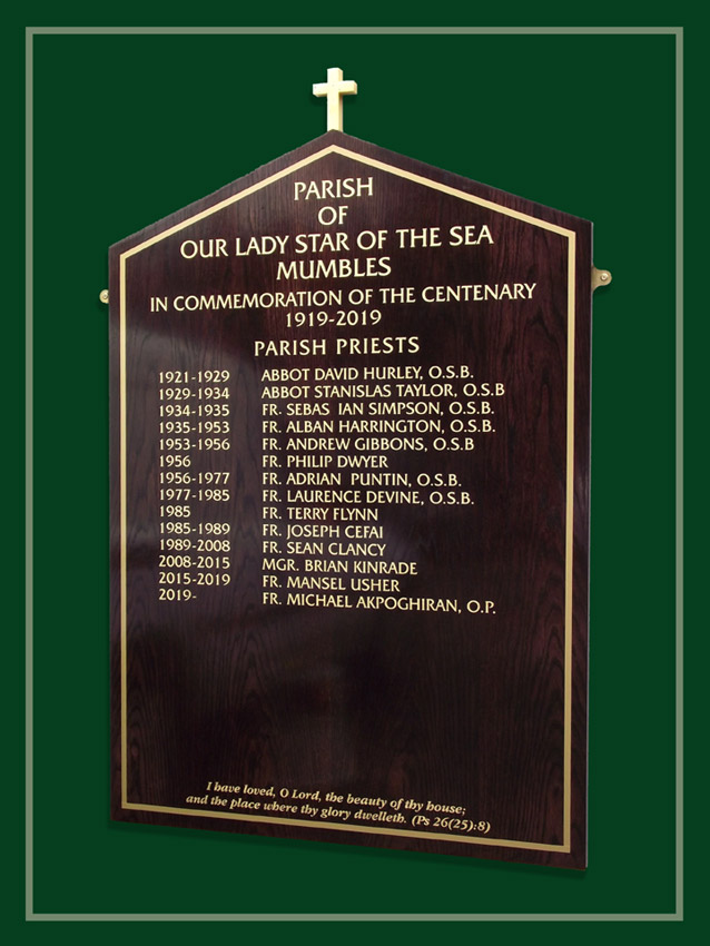 The names of parish priests are recorded in gold on deep reddy brown oak in this church in Wales.